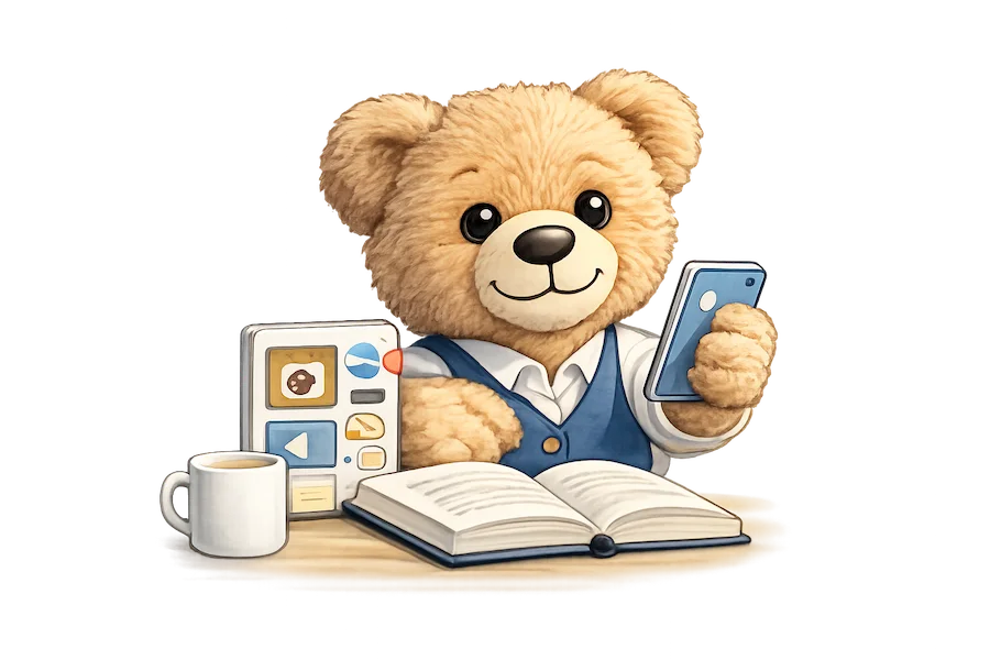 Teddy, die Markenfigur von Teddynews, sitzt am Schreibtisch mit Tablet, Telefon, aufgeschlagenem Buch und einer Tasse Kaffee